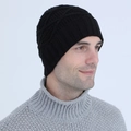 Black cable-knit beanie hat featuring ribbed edge shown on a model in grey sweater - Black