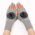 Detailed close-up of grey knitted fingerless gloves featuring large soft fur pom-poms - One Size / Light Gray