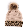 Close-up of beige knitted beanie featuring leopard print cuff and large faux fur pompom - Beige