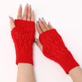 Macro detail of red knitted fingerless gloves showing hollow leaf pattern and ribbed cuff - Red