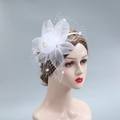 Detalle del tocado de novia con flor de malla blanca, perlas y velo de lunares suaves - Blanco