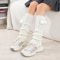 Detalle de calentadores blancos de punto trenzado con pompones y cordón ajustable - Blanco