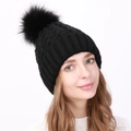 Berretto invernale da donna in maglia a trecce nera con grande pompon in ecopelliccia - Taglia unica / Nero