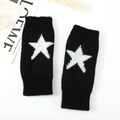 Detailopname van zwarte gebreide armwarmers met witte sterpatronen en geribbelde stof - Eén maat / Zwart