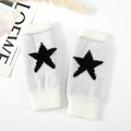 Detailopname van gebreide armwarmers met zwart sterpatroon op een witte achtergrond - Eén maat / Wit
