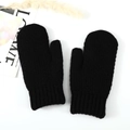 Detail view of black cable-knit mittens with ribbed cuffs on a minimalist white backdrop - Black