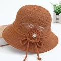Detail of a brown crochet sun hat featuring handcrafted floral accents and white pearls - One Size / Caramel color