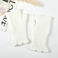 Dettaglio macro di guanti senza dita in maglia bianca a costine con eleganti bordi a balze - Bianco