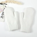Close-up of white knitted mittens showing soft wool texture and wide ribbed cuffs - White