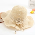 Beige knitted sun hat with wide wavy brim and 3D floral accent for summer beach style - One Size / Beige