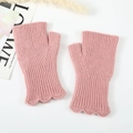 Detail of pink knitted fingerless gloves with scalloped edges and ribbed texture - Pink