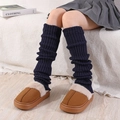 Gros plan de jambières en tricot bleu marine avec des chaussons en peluche sur le sol - Taille unique / Bleu marine