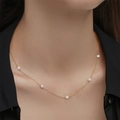 Primer plano de un collar de plata s925 dorada con perlas blancas y circonitas brillantes - Gargantilla de cadena fina dorada-Perlas y diamantes de imitación alternados