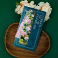 Detailed view of hollow brass rose bookmark with pink tassel on a wooden display tray - Rose