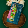 Detailed view of a golden brass hollow tulip bookmark with a vibrant pink tassel pendant - Tulip