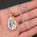 Detail eines religiösen Anhängers mit Maria und Jesus sowie einem goldenen Kreuz - Madonna und Kind Porträt mit Kette