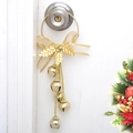 Goldene Weihnachtsglocken Deko mit Schleife und Stechpalmenblättern an weißer Tür - Gold Kreuzglocken / Gold