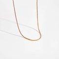 Gros plan d'un élégant collier tennis doré orné de pierres de zircone violettes et brillantes - Or 18K Pierre Violette