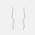 Vue détaillée des boucles d'oreilles vagues en argent S925 sur une surface lisse réfléchie - Platine