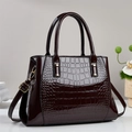Dunkelrote Handtasche mit Krokodilmuster, Lackleder-Optik und goldenen Metallbeschlägen - Kaffeebraun