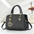 Elegante borsa a mano in pelle intrecciata nera con finiture dorate e ciondolo - Nero