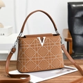 Brown plaid crossbody bag with V logo and crystal studs on a wooden desk setting - Earthy Yellow