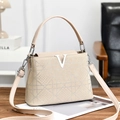 Beige rhinestone tote bag with V-logo and crossbody strap on a wooden table - Khaki
