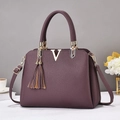 Détail du sac à main violet en cuir grainé avec logo V doré et doubles glands chic - 32x13x23cm / Violet