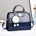 Dettaglio della borsa in pelle verniciata blu scuro con goffratura a triangoli e logo - Blu