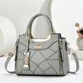 Dettaglio borsa a mano grigia in pelle con cuciture geometriche e logo in metallo dorato - 23.5*9*19 / Grigio