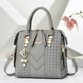 Detail of grey pebbled leather handbag with V-shaped weave and pearl metal charm pendant - Tag Charm Style / Gray