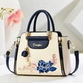 Elegant two-tone beige and blue handbag with floral embroidery and decorative charm - Blue