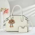 Chic beige tote bag set with brown bear plush charm and mini pouch on decorative props - Off White
