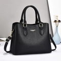 Detail of black lychee grain leather handbag with gold hardware and shoulder strap - Black