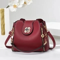 Elegant burgundy leather handbag with gold floral clasp on white geometric pedestal - Wine Red