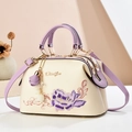 Elegante cremeweiße Handtasche mit lilafarbener Blumenstickerei und Taschenanhänger - Lila