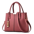 Detalle de bolso rosa con textura de cuero, adorno dorado y correa larga ajustable - Rosa Caucho