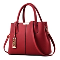 Elegante bolso de mano de cuero rojo con hebillas doradas y correa sobre fondo blanco - Burdeos