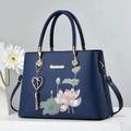 Elegant navy blue lotus embroidery handbag with golden tassel charm and metal logo - Blue