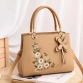 Elegante khakifarbene Handtasche aus Kunstleder mit weißer Blumenstickerei und Schmetterling - Khaki