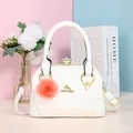 Détail du sac à main blanc en cuir avec logo doré et pendentif fleur de rose - Blanc