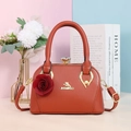 Vue détaillée du sac en similicuir orange avec fermoir doré et ornement floral rouge - Rouge pastèque