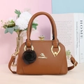 Dettaglio borsa in pelle PU marrone con logo gatto dorato, chiusura con gemma e fiori - Giallo ocra