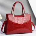 Détail du sac à main rouge en similicuir croco avec logo doré et doubles poignées de luxe - Rouge