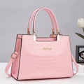Détail de la texture crocodile rose et logo doré sur le sac à main élégant pour femme - Rose