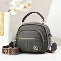Close-up of pebble leather shoulder bag featuring golden K logo and floral strap detail - Gray