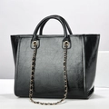 Detail of black oil-wax textured tote bag with golden chain strap and round handles - Black