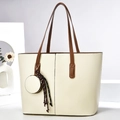 Cream tote bag set with brown straps and mini round charm on minimalist background - Off White