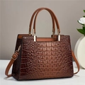 Detalle de bolso tote marrón con textura de cocodrilo y herrajes dorados elegantes - Marrón Café