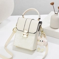 Cream snake embossed crossbody handbag with golden clasp and pink furry charm - Off White